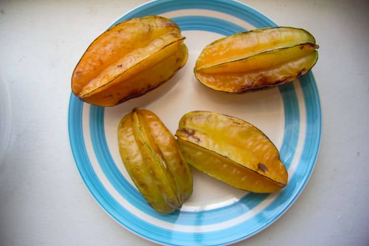 Four star fruit chips on a blue plate.