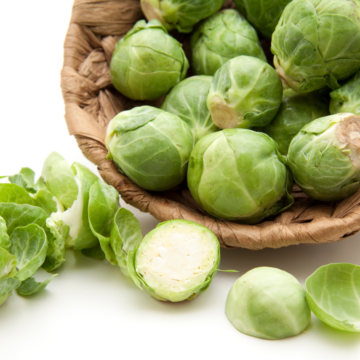 High protein Brussels sprouts in a basket on a white surface.