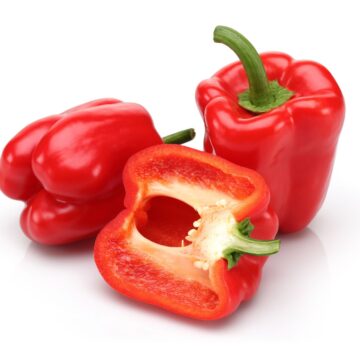 Three red peppers on a white background, showcasing nutritious and vibrant low carb vegetables.