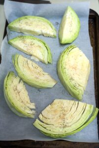 Sliced artichokes on a baking sheet for cabbage gratin.