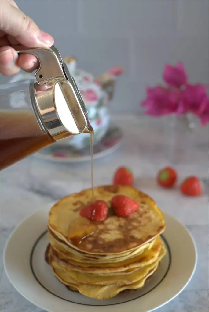 syrup poured over a stack of pancakes