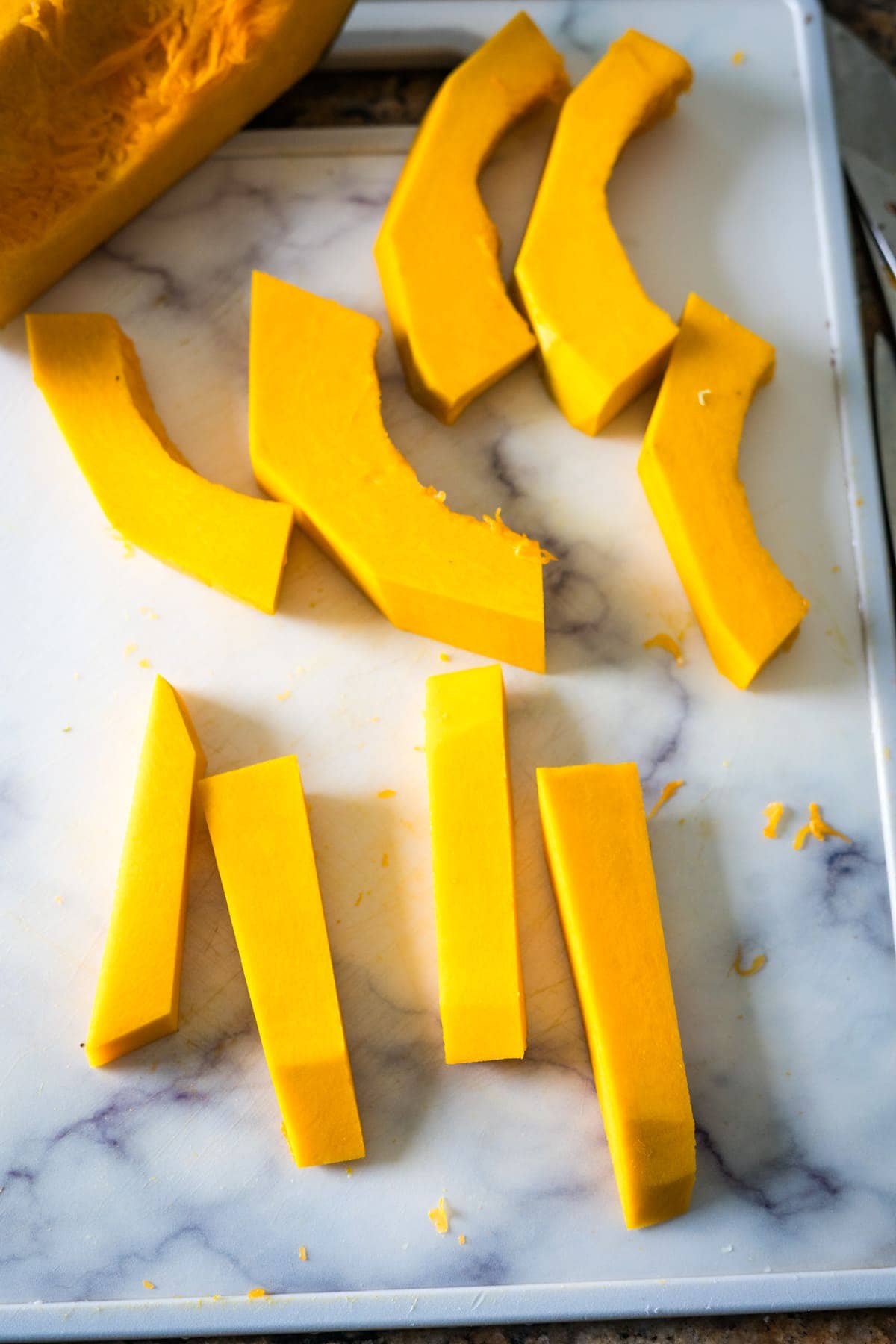 Sliced squash (pumpkin) on a cutting board next to a knife.