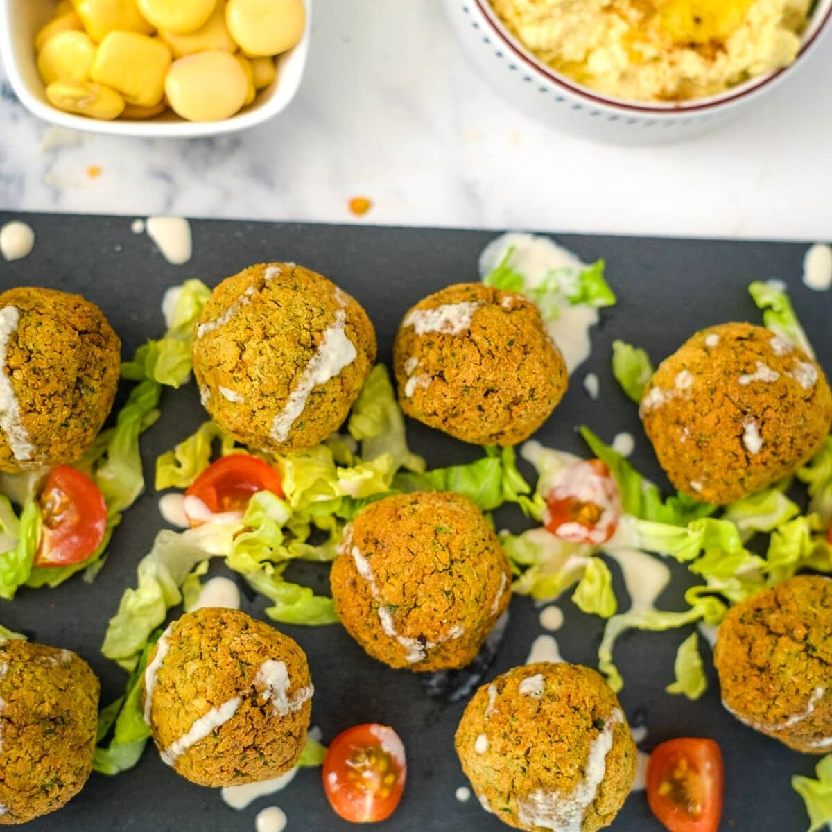 A tray of keto falafel balls and salad on a table.
