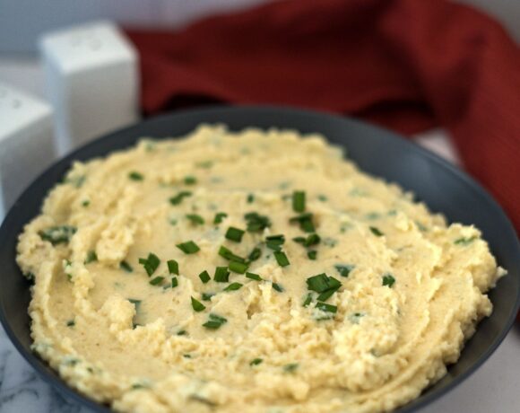 A bowl of low carb mashed potatoes with chives.