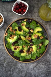 Avocado spinach salad with cranberries and walnuts.