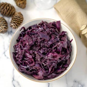 Festive red cabbage in a bowl on a marble table.