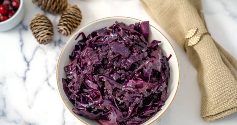 Festive red cabbage in a bowl on a marble table.