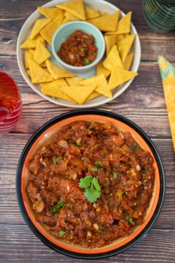 a bowl of chipotle tomato salsa with a bowl of tortilla chips