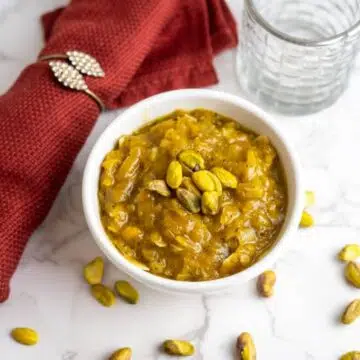 Pumpkin Halwa topped with pistachio nuts in a white bowl.