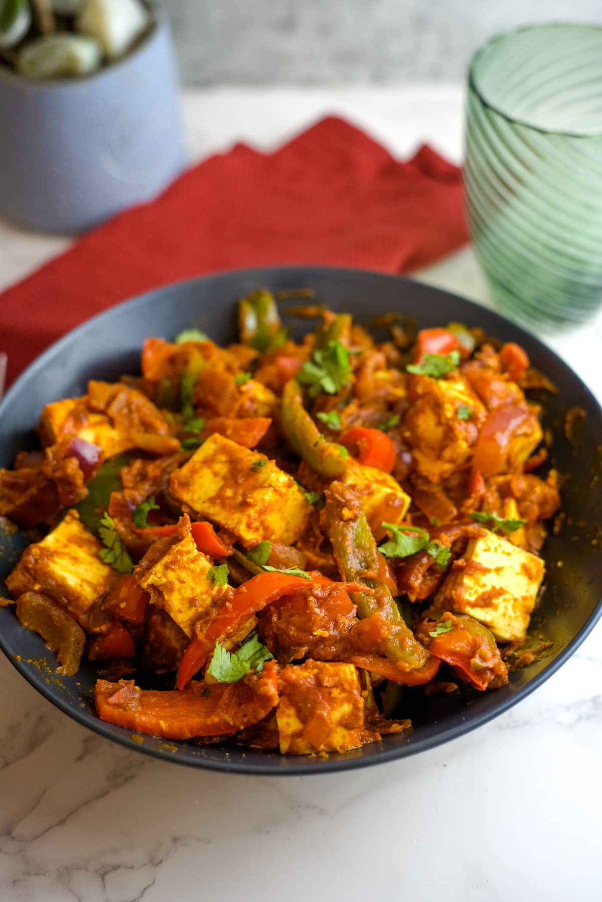 a bowl of paneer chunks in a spicy tomato sauce