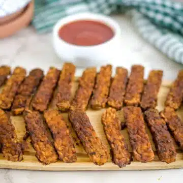 air fryer tempeh bacon slices on a wooden board