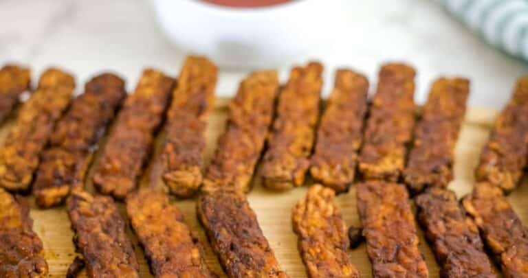 air fryer tempeh bacon slices on a wooden board