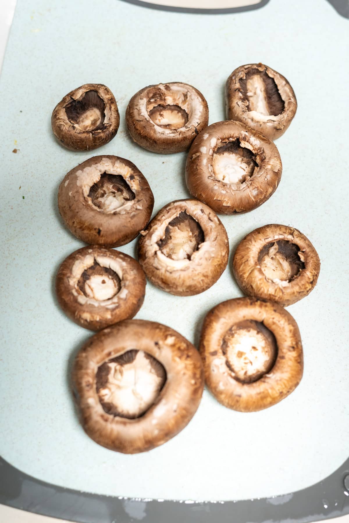 Sliced mushrooms on a cutting board ready for air fryer.