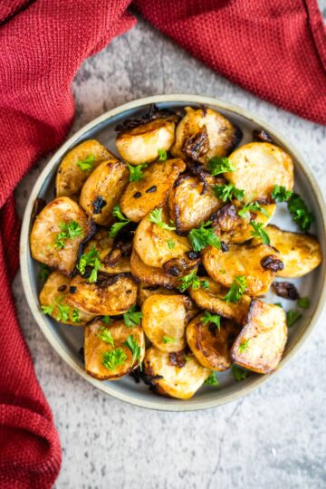 Roasted potatoes with fried turnips on a plate.