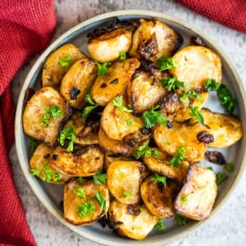 Roasted potatoes in a bowl with parsley.