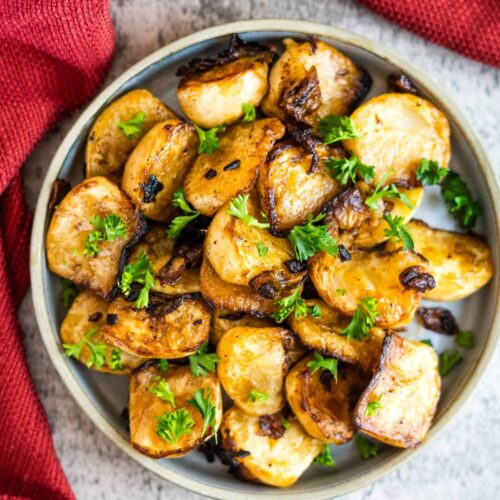 Roasted potatoes in a bowl with parsley.