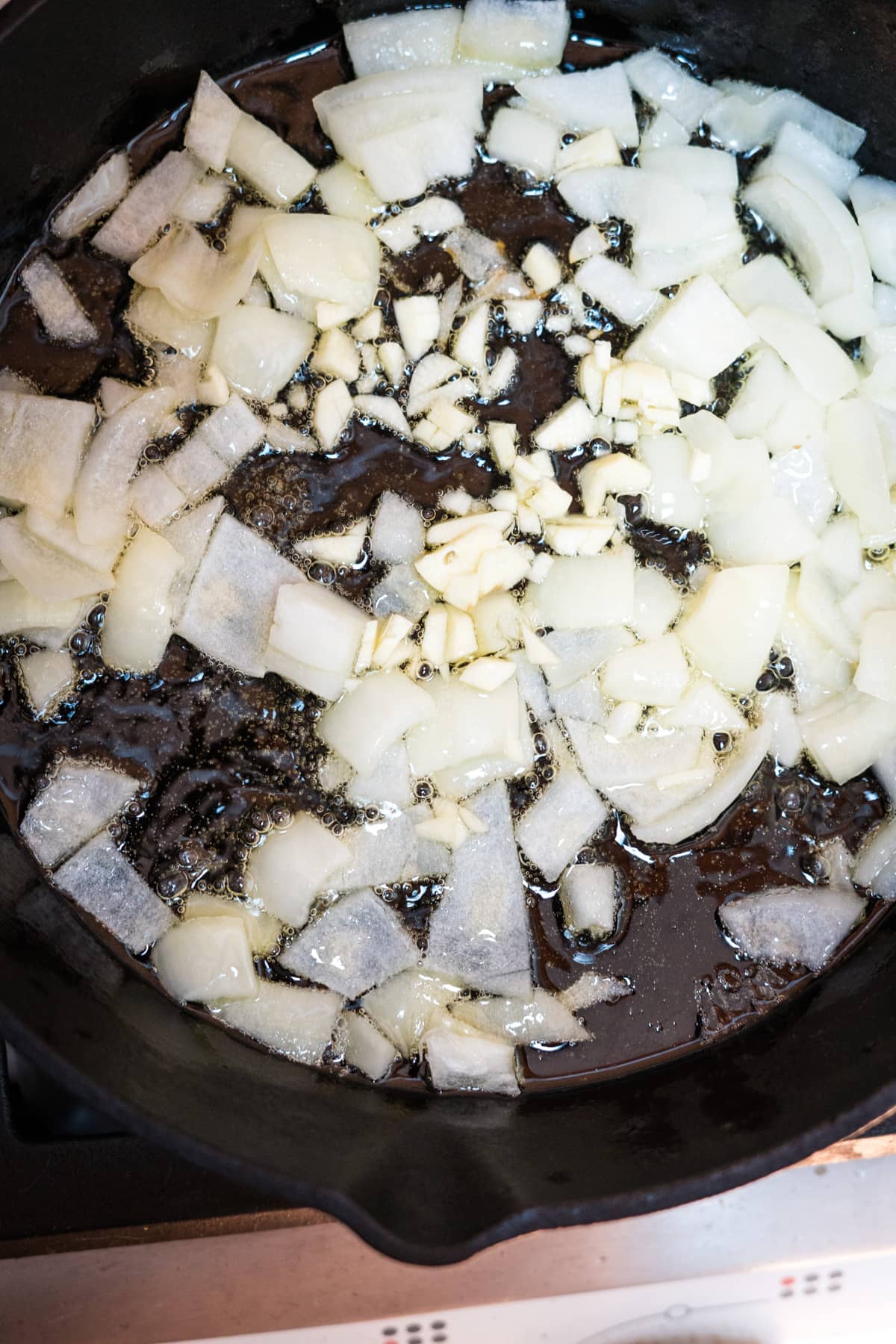 A pan with fried onions in it cooking on a stove.