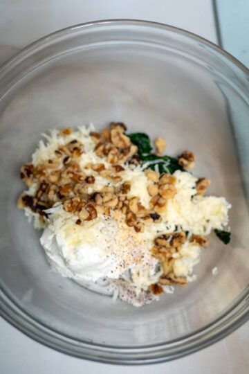 An air fryer recipe featuring stuffed mushrooms filled with cheese, spinach, and walnuts.