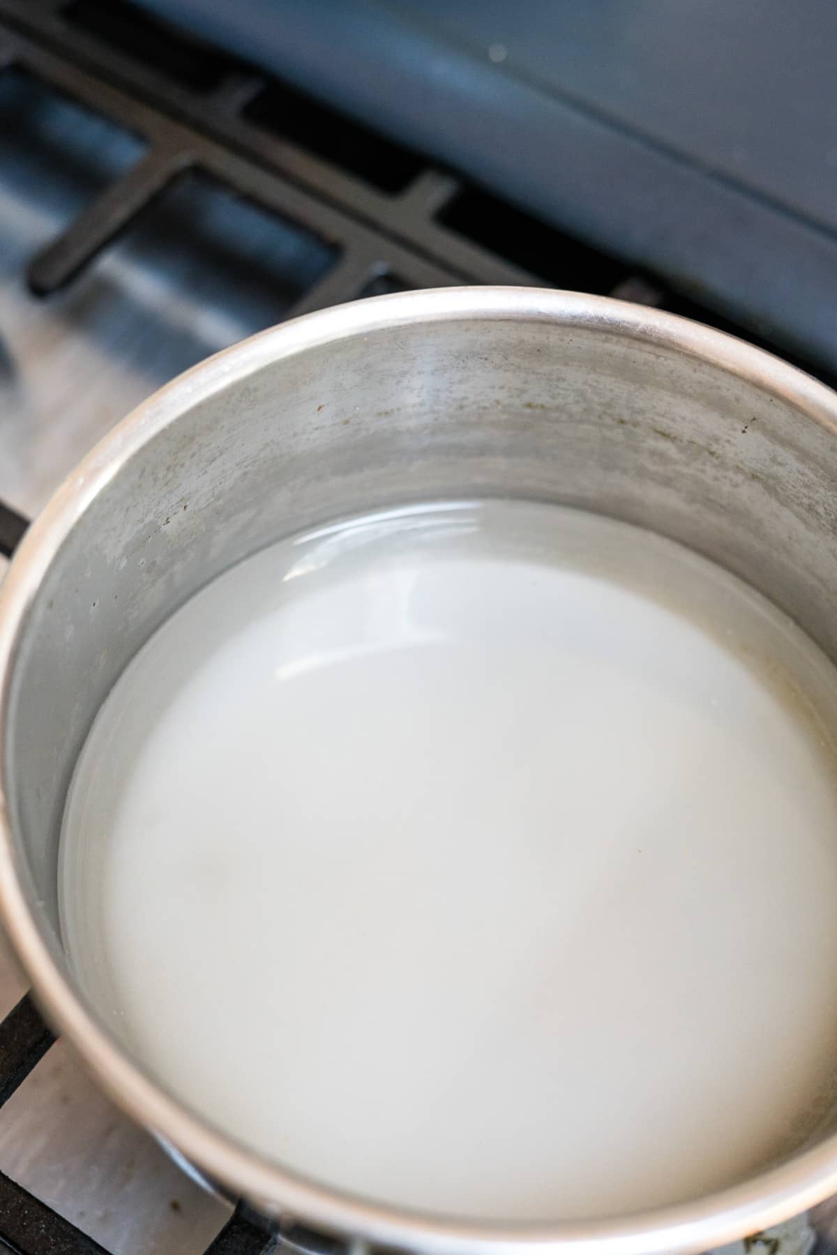 A bowl of milk sitting on top of a stove.