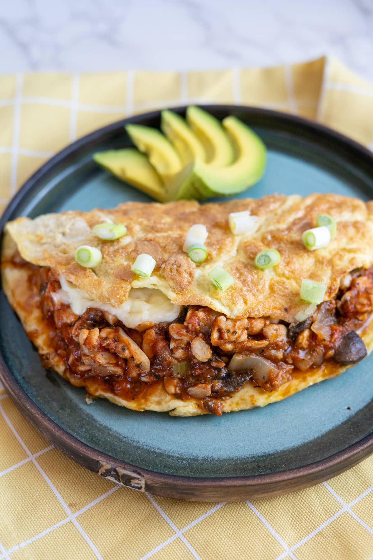 A chili omelette with avocado on a plate.