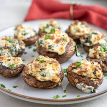 Stuffed mushrooms with spinach and cheese on a plate.
