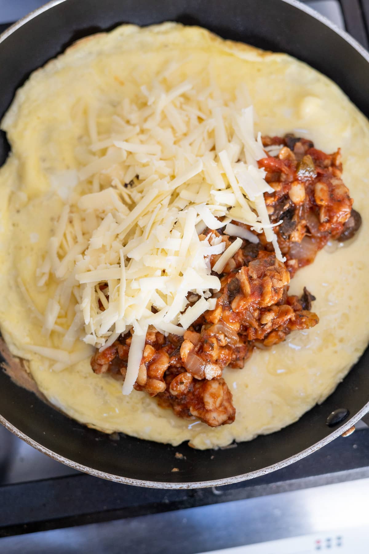 An omelette with chili and cheese in a pan.