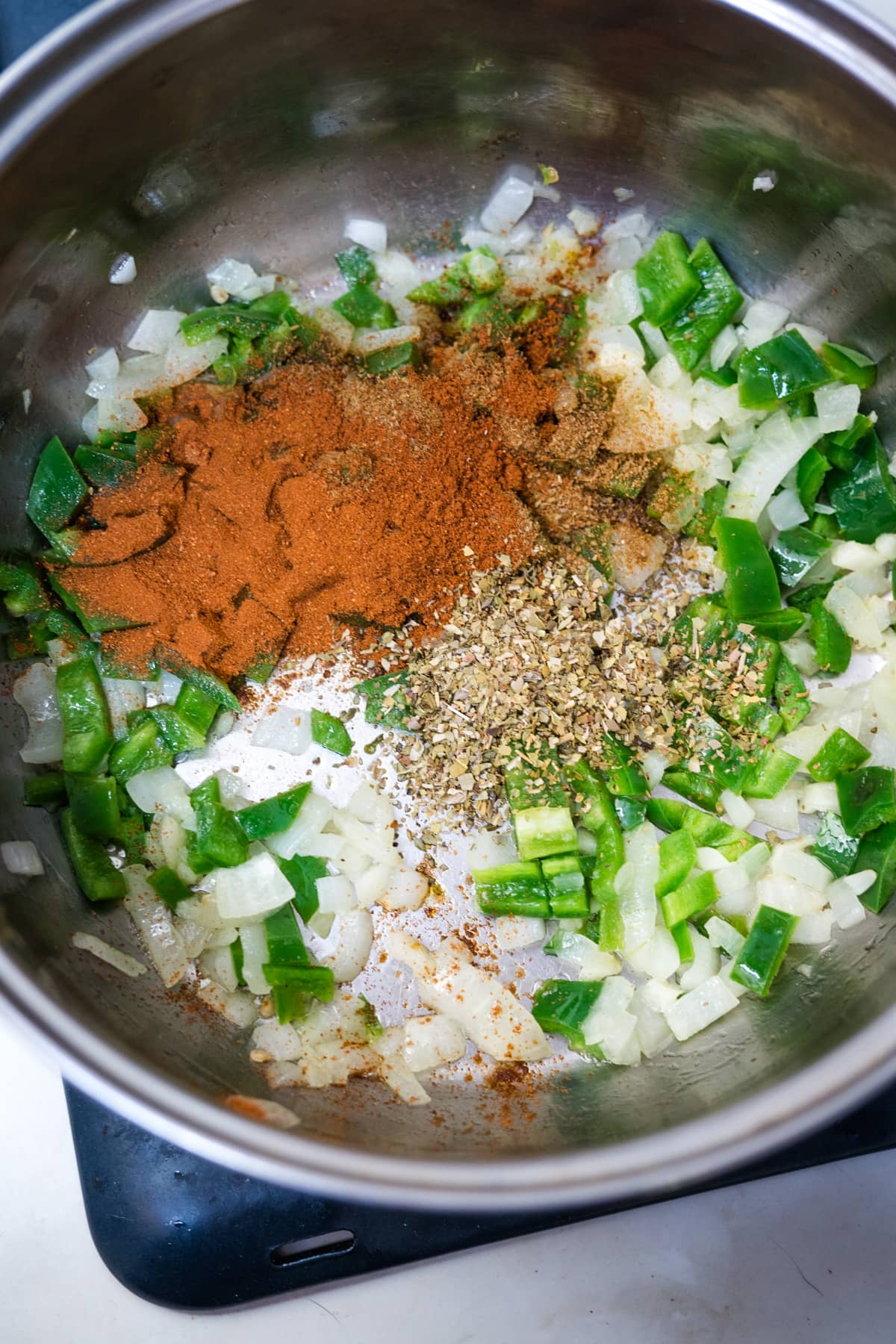 Ingredients for TVP chili in a bowl on top of a stove.