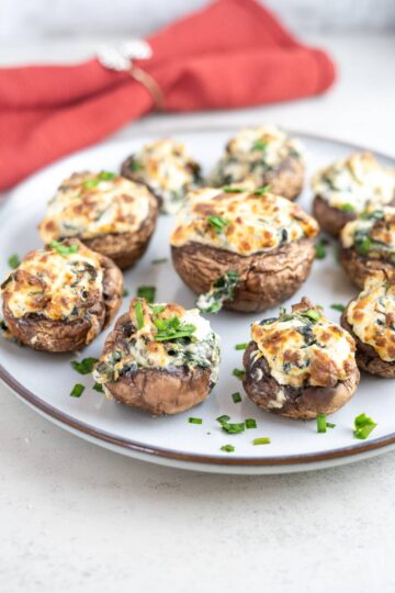 Air-fried stuffed mushrooms with spinach and cheese on a plate.