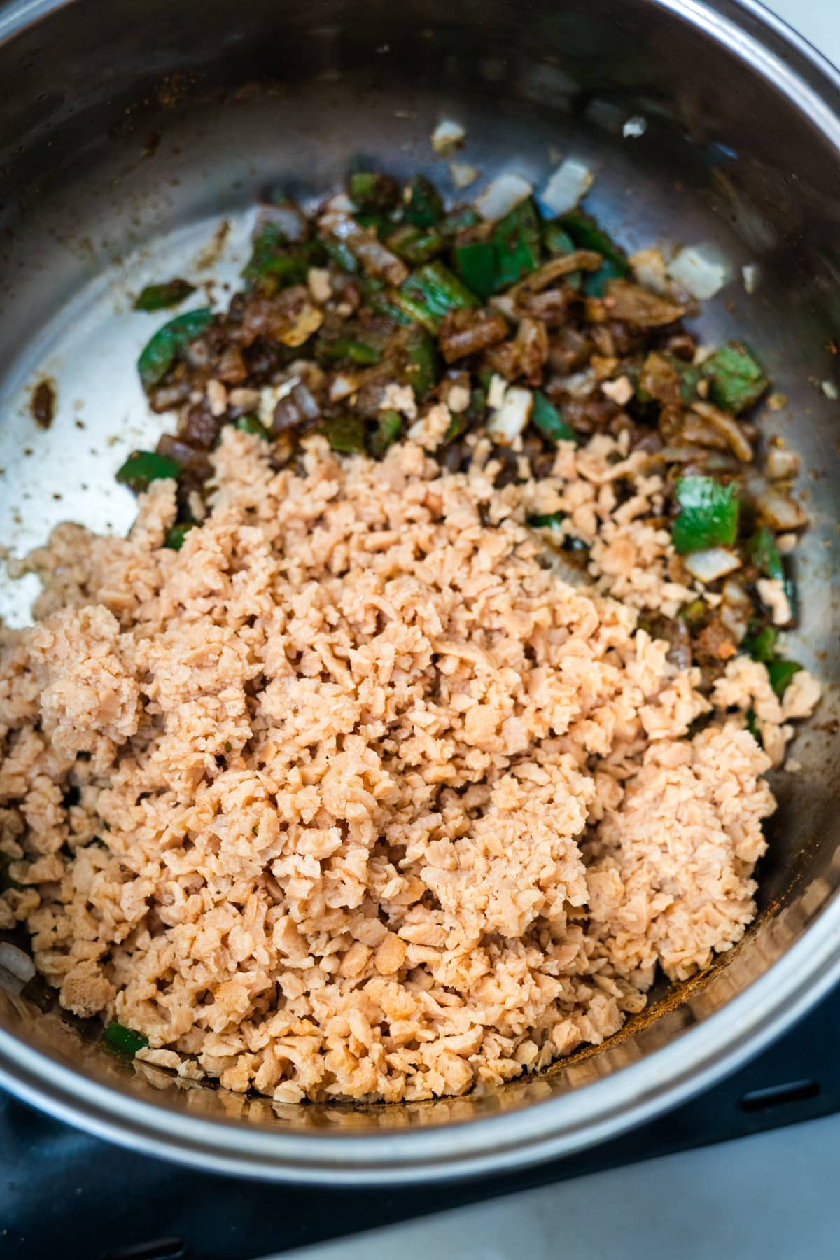 A bowl of rice and TVP chili on a stove top.