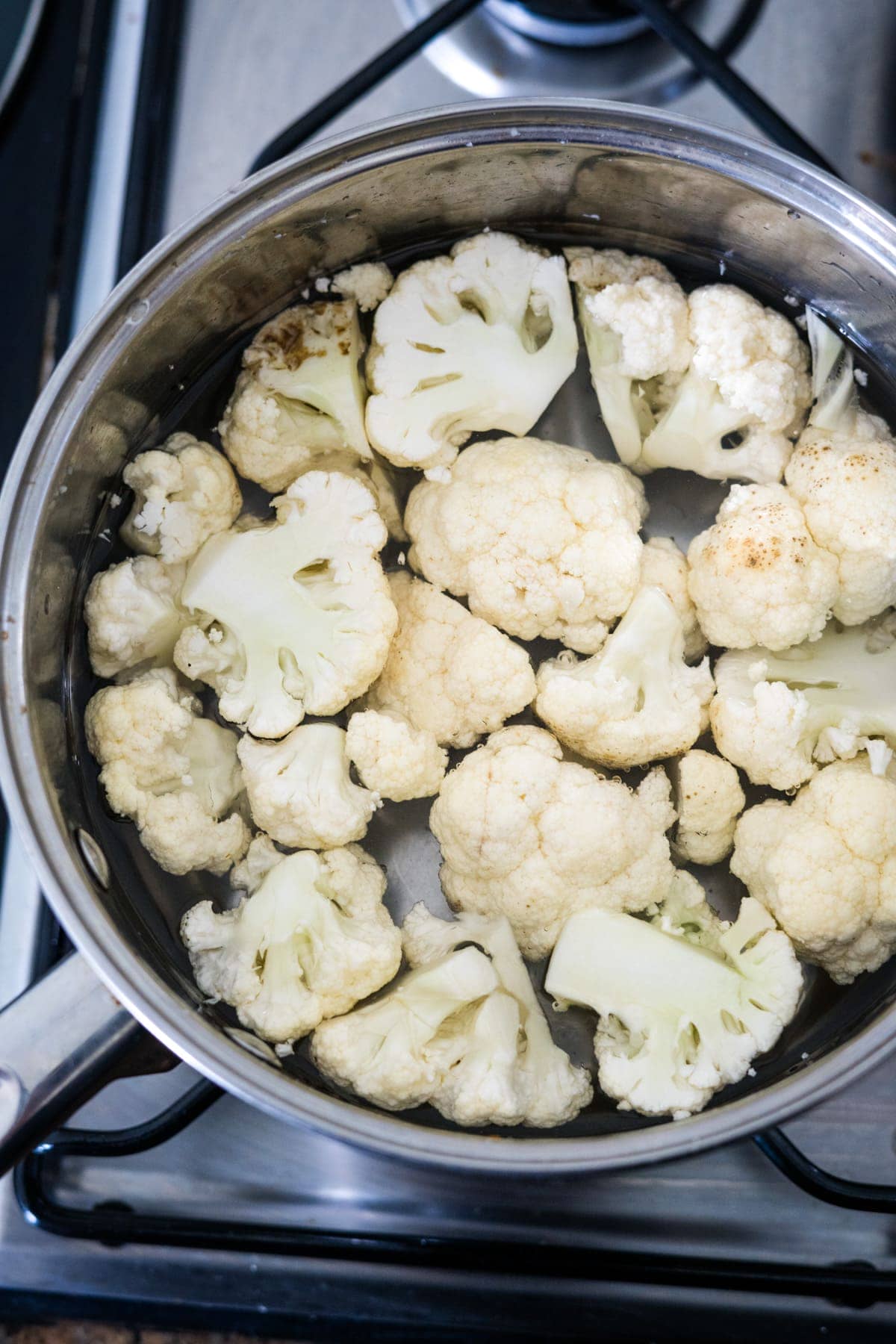 Mushroom and leek cottage pie with cauliflower cooked in a pan on a stove.