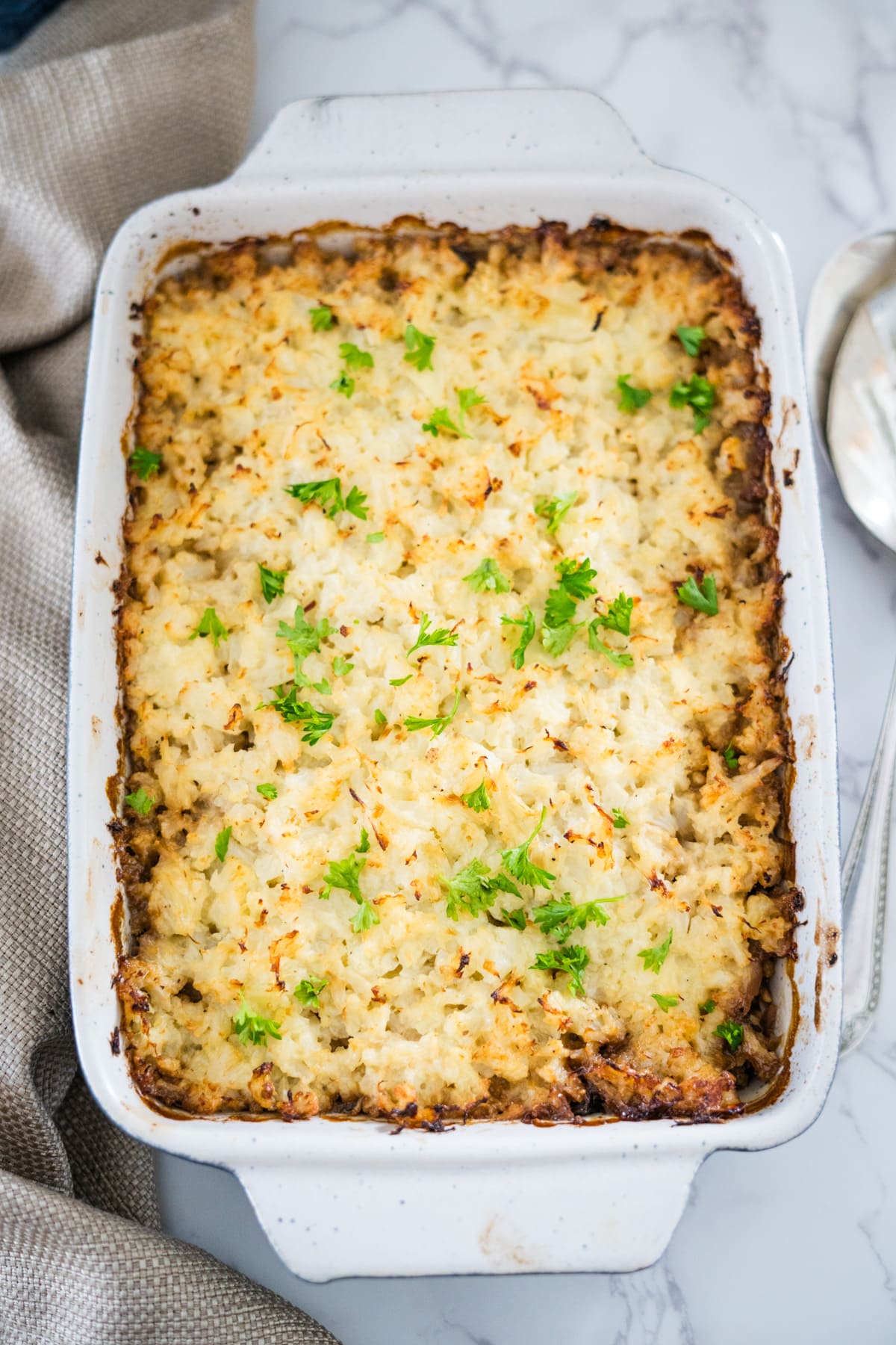 A mushroom and leek cottage pie with mashed potatoes and parsley.