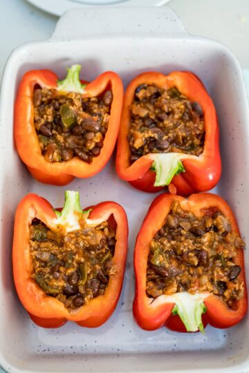 Stuffed peppers with black beans in a baking dish.