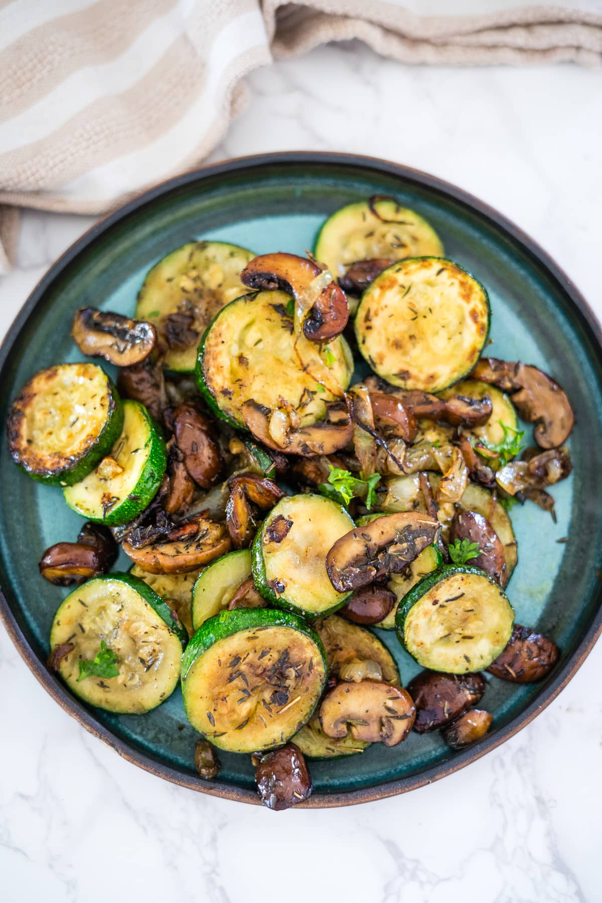 Grilled zucchini and mushrooms on a plate.