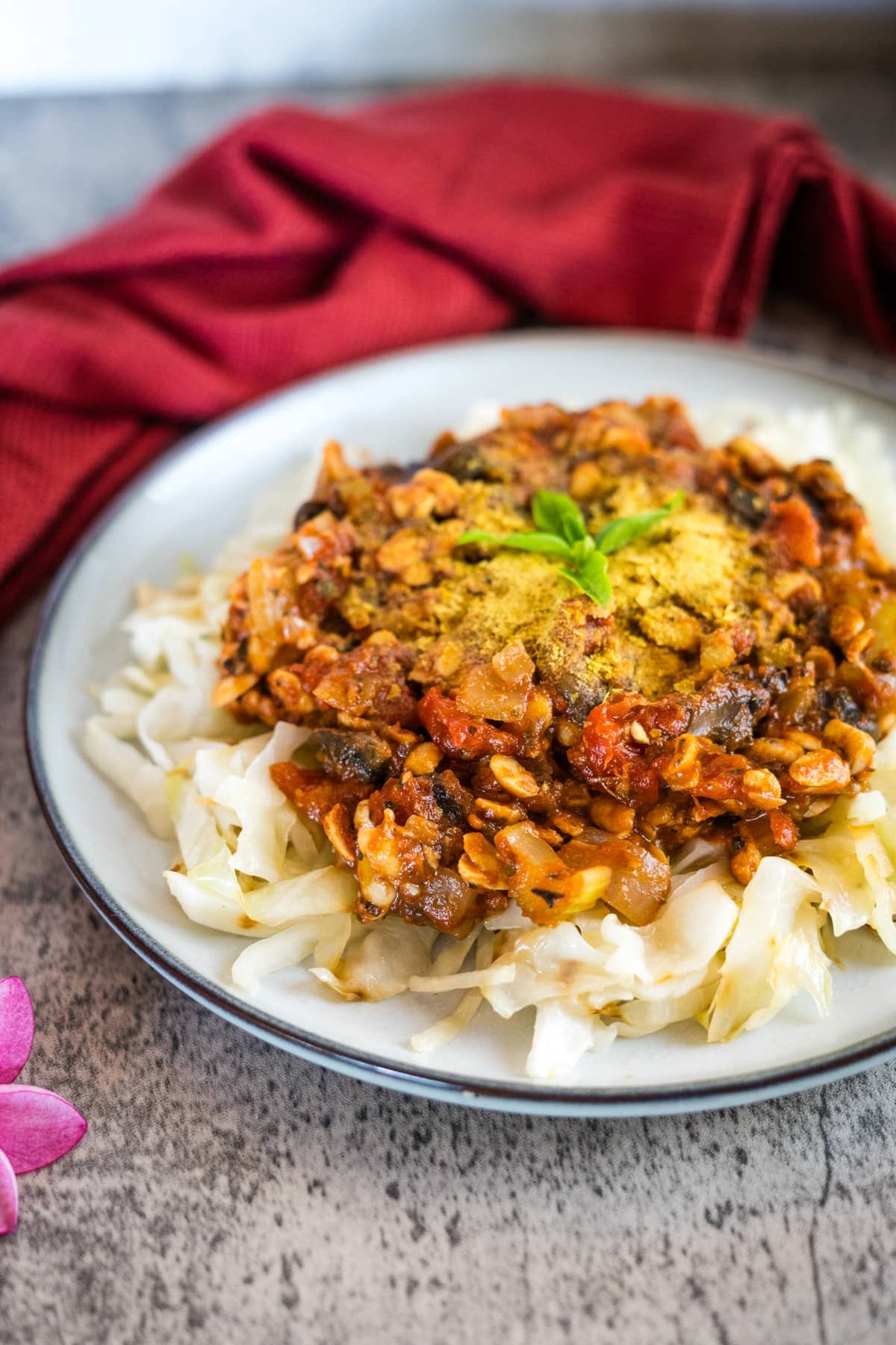 A plate of tempeh noodles and curry on a table.