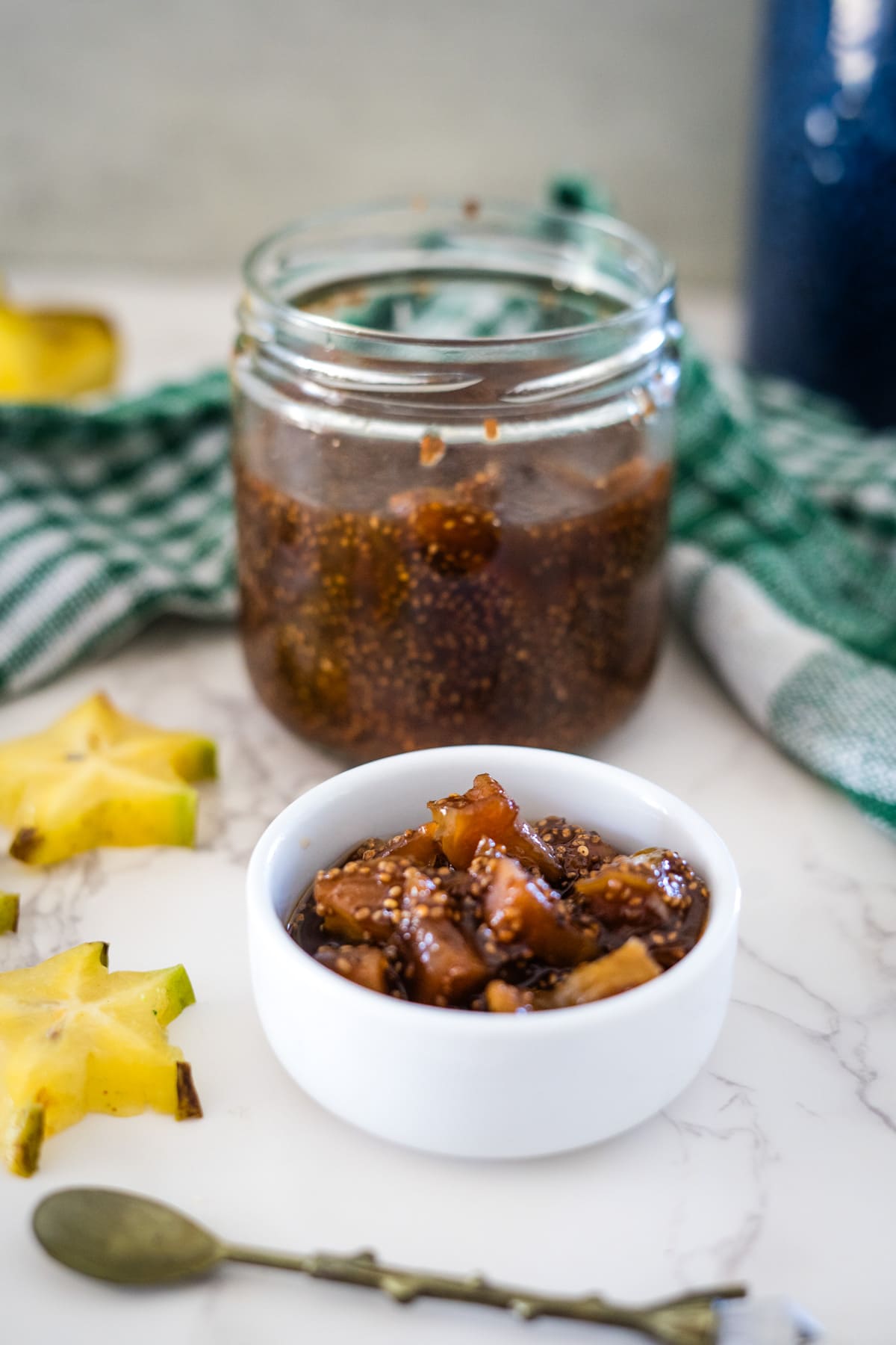 A jar of star fruit jam with a spoon next to it.
