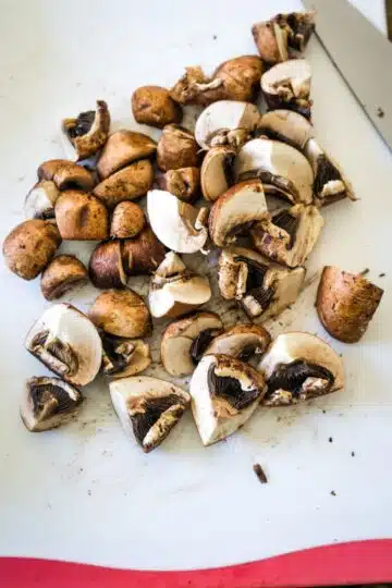 Sliced mushrooms on a cutting board for mushroom tofu soup.