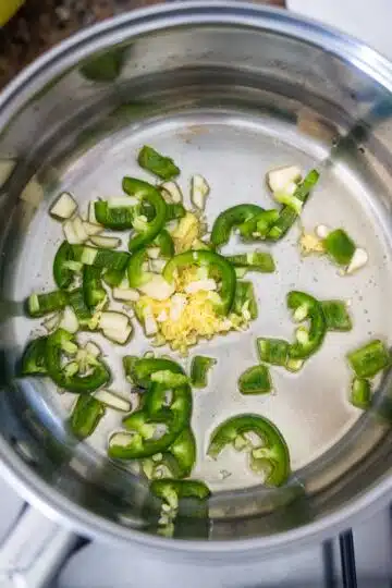 A pan with green peppers and onions in it.