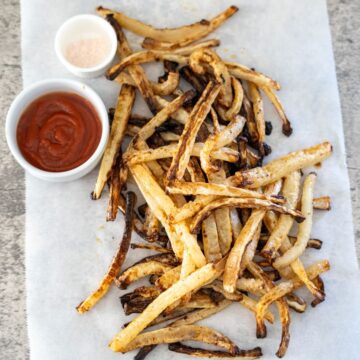 Grilled french fries with ketchup and dipping sauce.