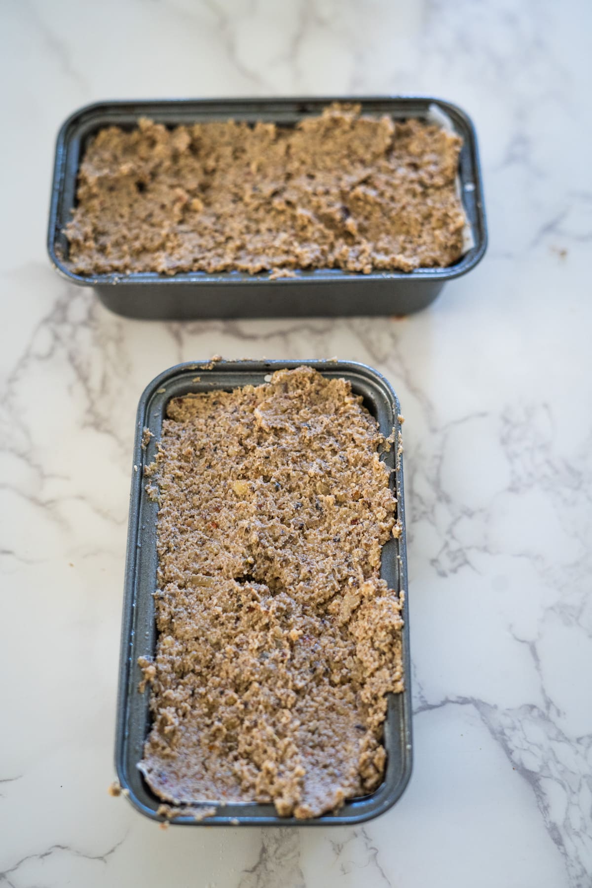 Two trays of granola sitting on top of each other in an air fryer.