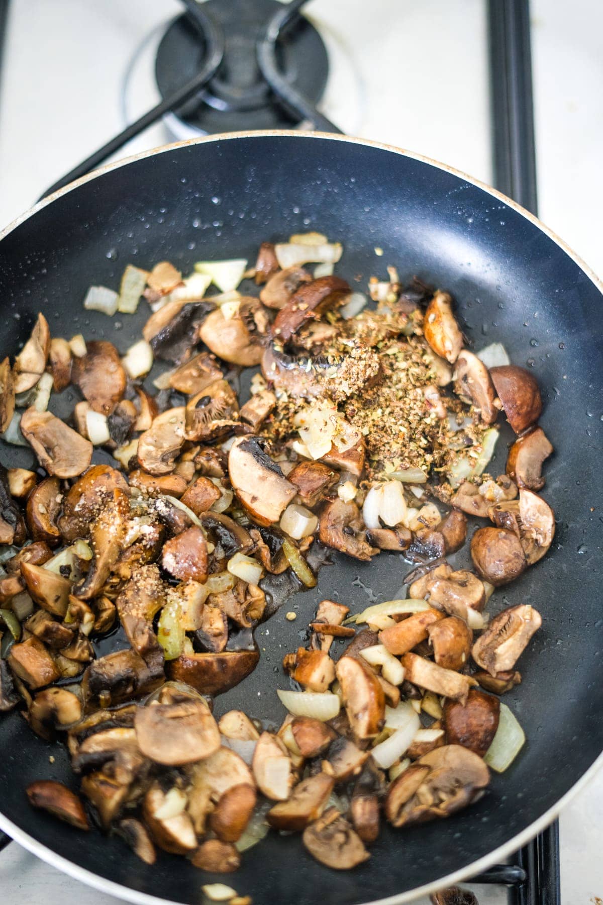 An air fryer with mushrooms and onions on it.