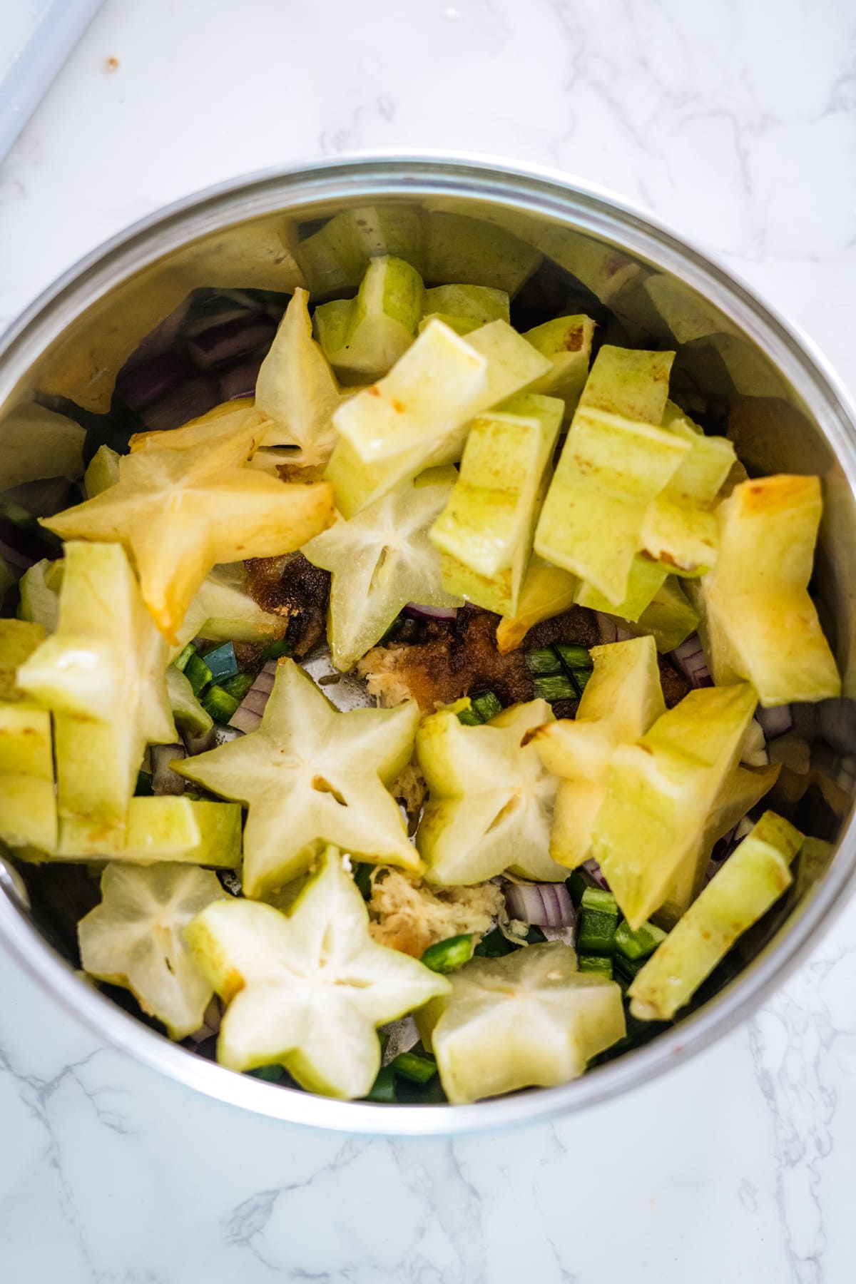 A bowl full of chopped apples, celery, and star fruit chutney.