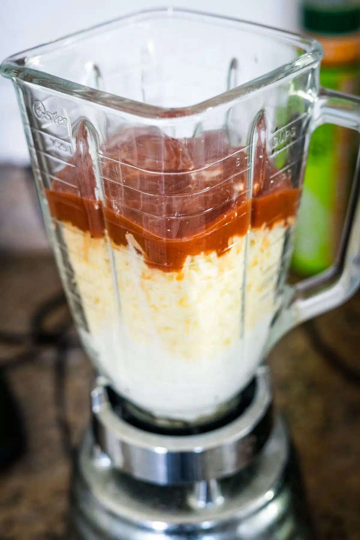 A blender filled with a mixture of cottage cheese and pizza ingredients.