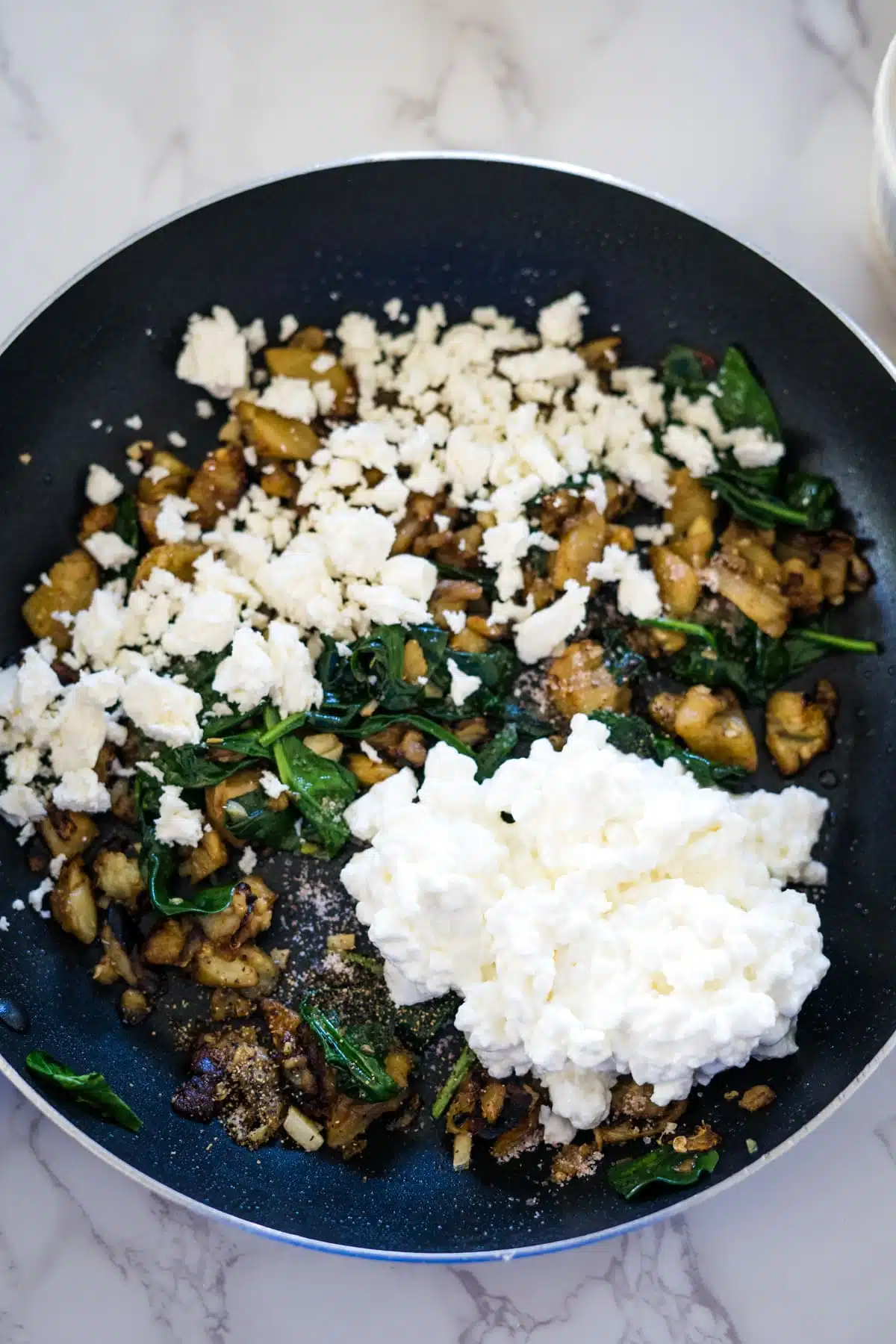 A delicious eggplant boats stuffed with spinach and feta cheese cooked in a frying pan.