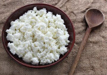 A bowl of cottage cheese with a wooden spoon.