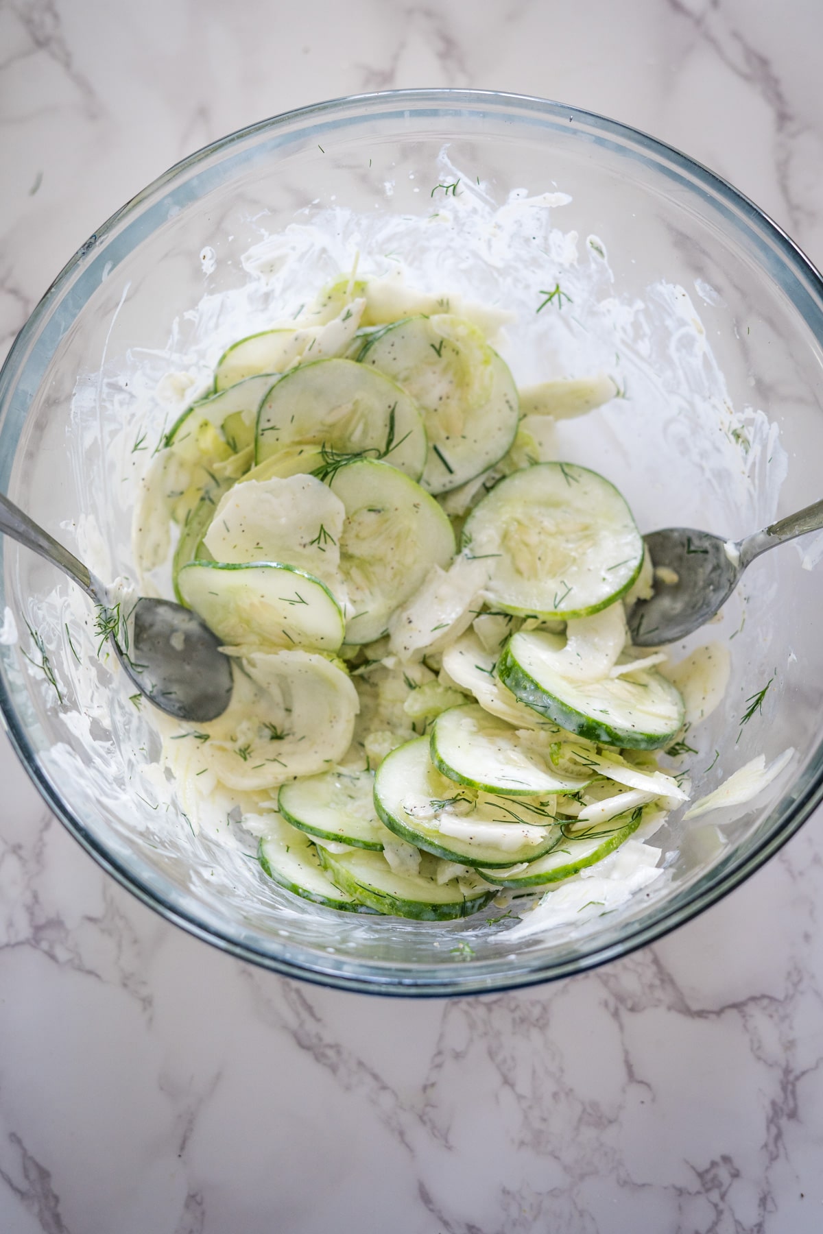 Cucumber and fennel salad in a glass bowl.