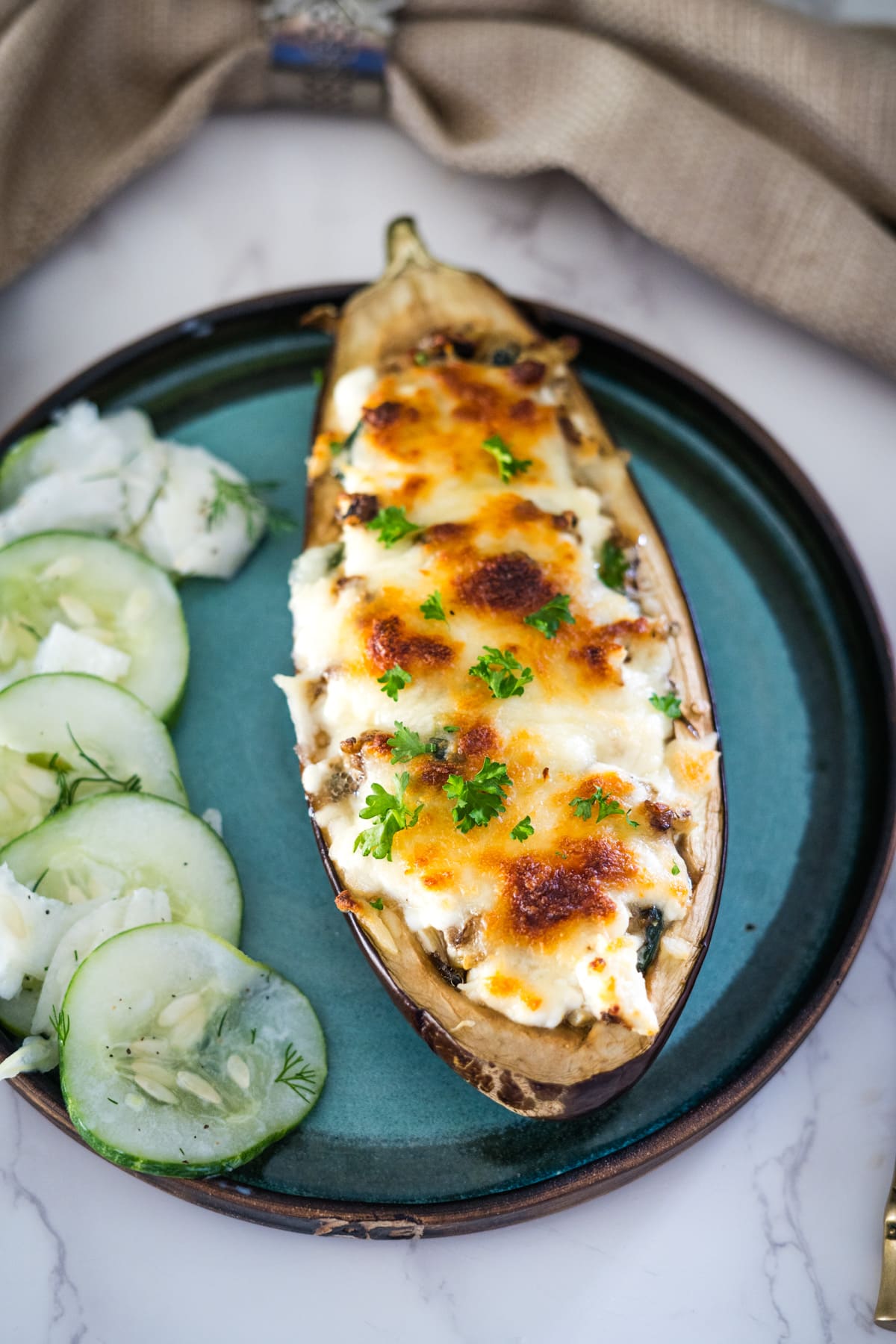 Eggplant boats stuffed with feta cheese and cucumbers on a plate.