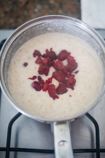 A pan with raspberries in it simmering on a stove.