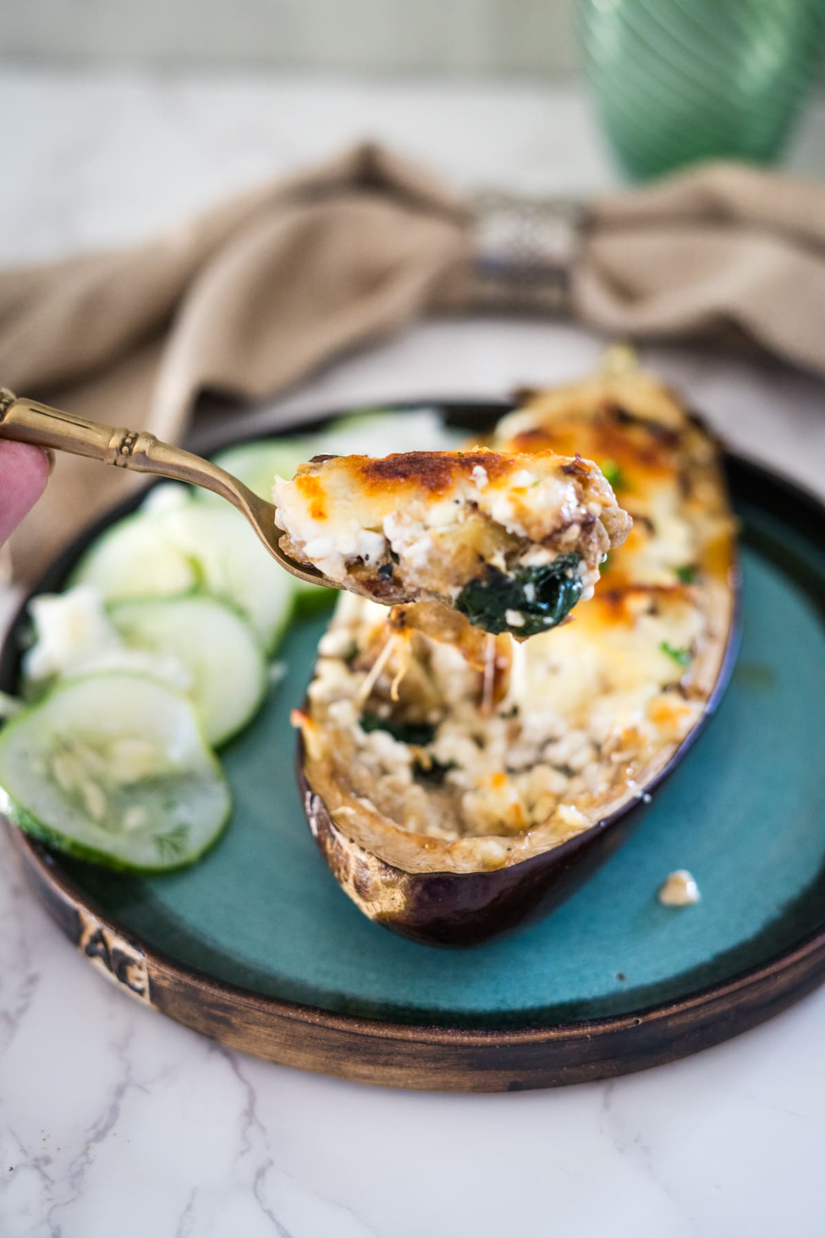 Eggplant boats stuffed with cheese and spinach on a plate.