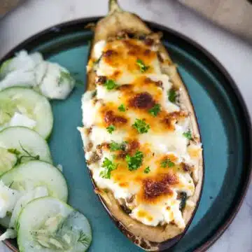Stuffed eggplant with feta cheese and cucumbers on a plate.