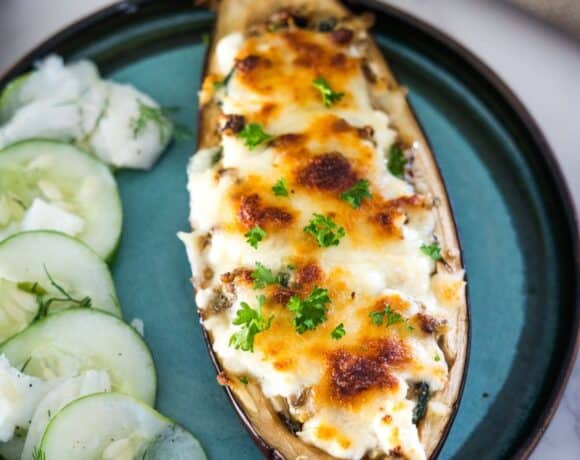 Stuffed eggplant with feta cheese and cucumbers on a plate.